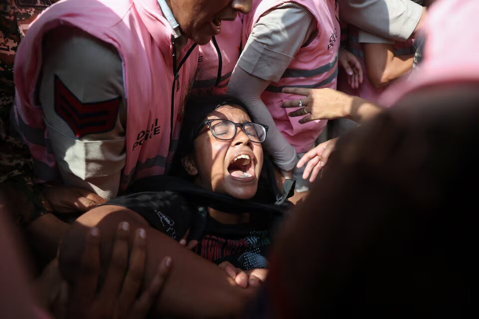 এক নারী বিক্ষোভকারীকে ধরে রেখেছেন দিল্লি পুলিশের সদস্যরা